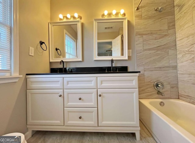 bathroom featuring vanity and tiled shower / bath combo