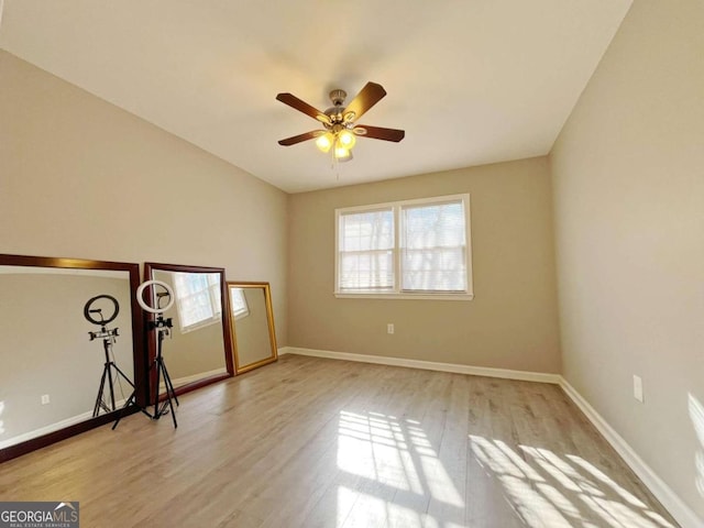 empty room with ceiling fan and light hardwood / wood-style floors