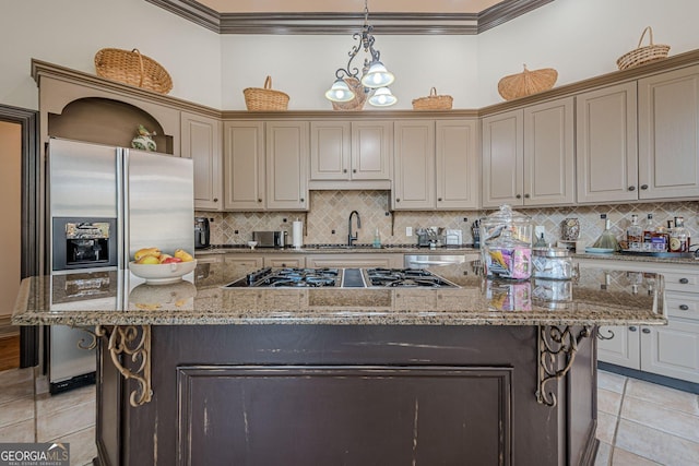 kitchen with light tile patterned floors, stainless steel appliances, a sink, ornamental molding, and a center island