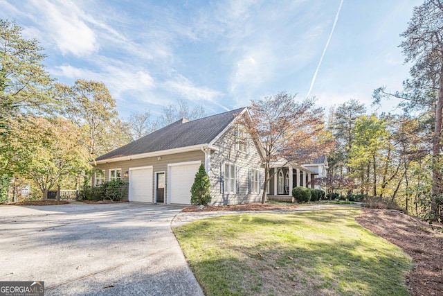 view of property exterior featuring a garage, a lawn, and a sunroom