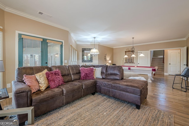 living area with french doors, visible vents, ornamental molding, wood finished floors, and stairs