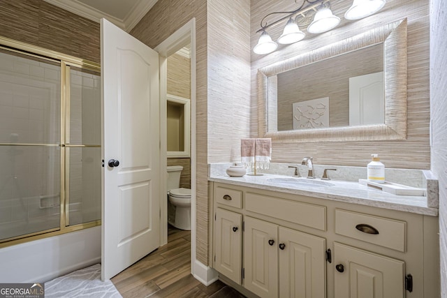 full bath featuring shower / bath combination with glass door, crown molding, toilet, vanity, and wood finished floors