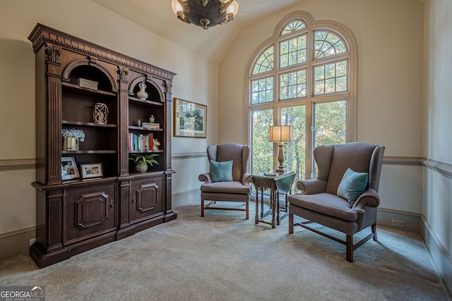 living area featuring carpet floors, an inviting chandelier, plenty of natural light, and lofted ceiling