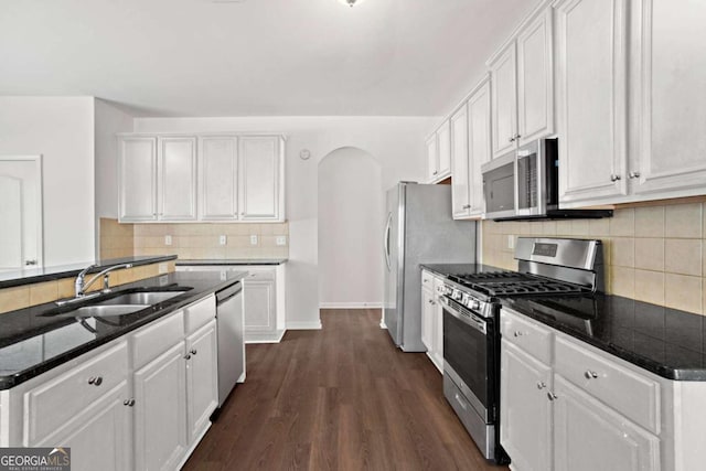 kitchen featuring white cabinets, stainless steel appliances, sink, and dark wood-type flooring