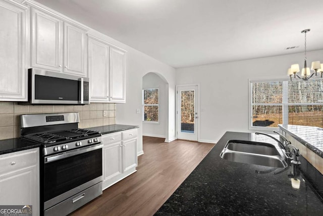 kitchen with sink, decorative light fixtures, white cabinetry, an inviting chandelier, and appliances with stainless steel finishes