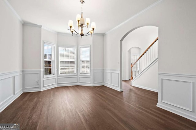 unfurnished dining area featuring dark hardwood / wood-style flooring, ornamental molding, and a notable chandelier