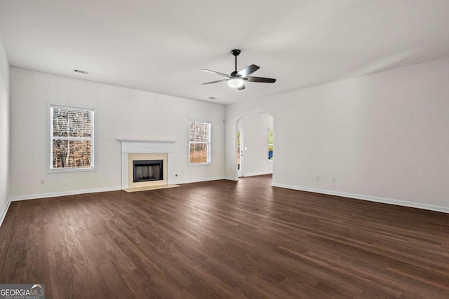 unfurnished living room featuring ceiling fan and dark hardwood / wood-style floors