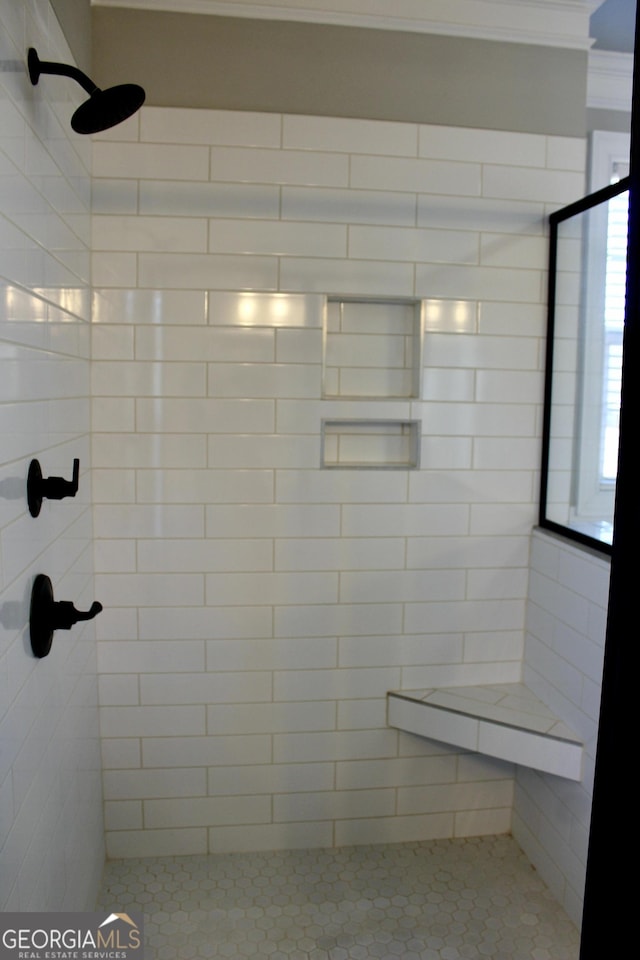 bathroom featuring ornamental molding and tiled shower