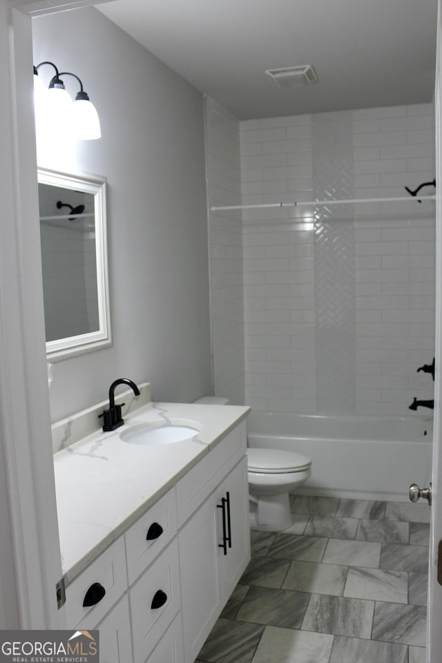 full bathroom featuring toilet, tiled shower / bath, and vanity