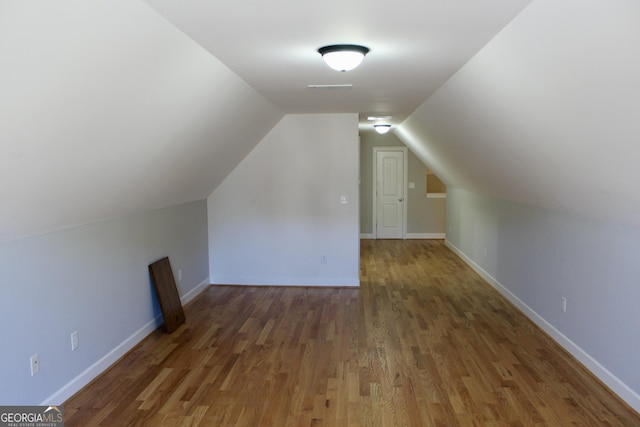 additional living space with dark wood-type flooring and lofted ceiling