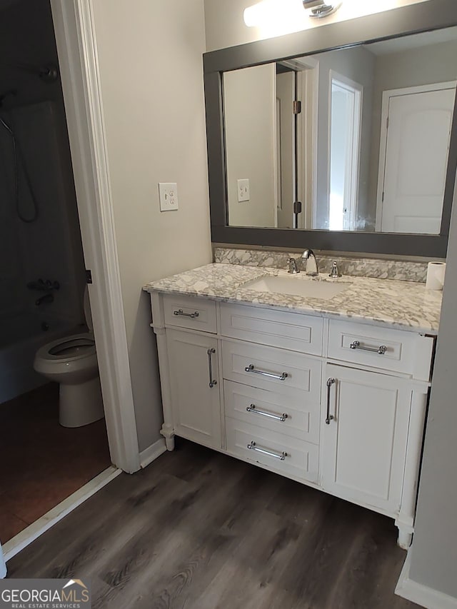 bathroom with toilet, hardwood / wood-style flooring, and vanity