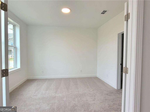 carpeted empty room featuring plenty of natural light