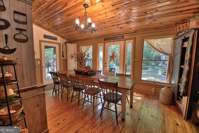 kitchen featuring black appliances, hanging light fixtures, sink, light hardwood / wood-style flooring, and an inviting chandelier