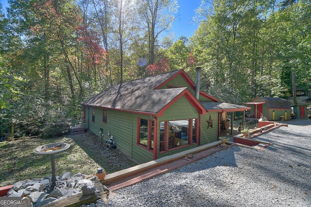 view of side of home with a fire pit and a shed