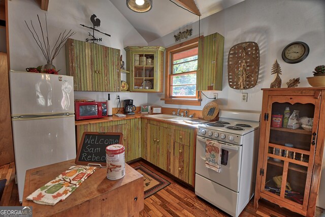 kitchen featuring white appliances, lofted ceiling, sink, and wood-type flooring