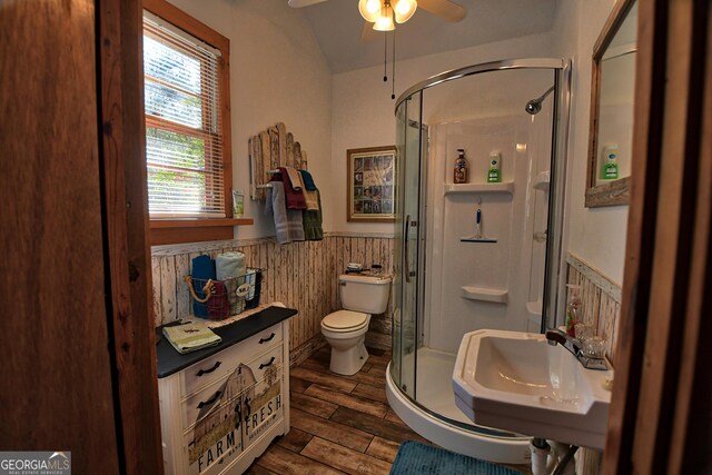 bathroom with sink, lofted ceiling, ceiling fan, toilet, and a shower with door