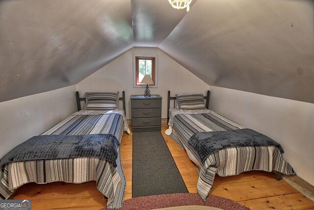 bedroom featuring lofted ceiling and light hardwood / wood-style flooring