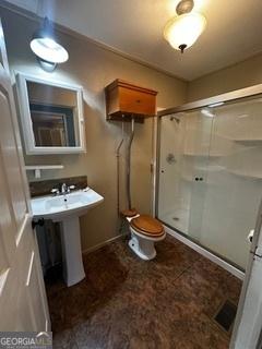 bathroom with toilet and a shower with shower door