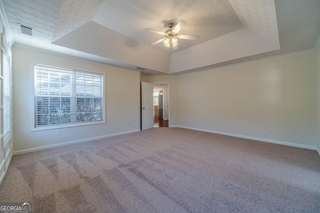 carpeted empty room with ceiling fan, crown molding, a tray ceiling, and a textured ceiling