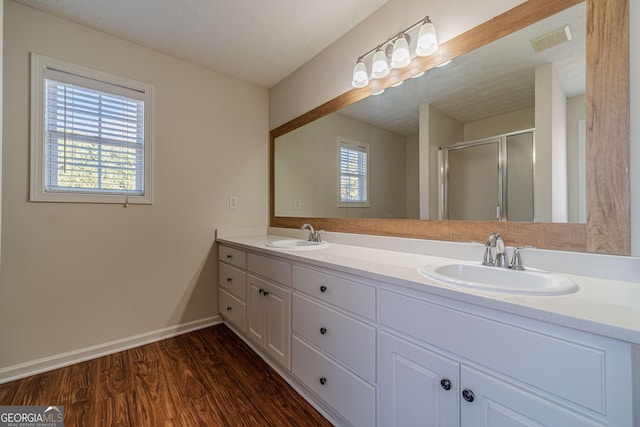 bathroom featuring vanity, a textured ceiling, a healthy amount of sunlight, and hardwood / wood-style floors