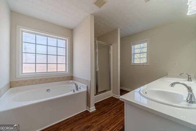 bathroom featuring hardwood / wood-style flooring, a textured ceiling, vanity, and shower with separate bathtub