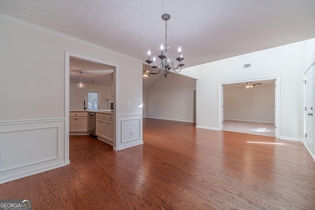 unfurnished dining area featuring a textured ceiling, ceiling fan with notable chandelier, and hardwood / wood-style flooring