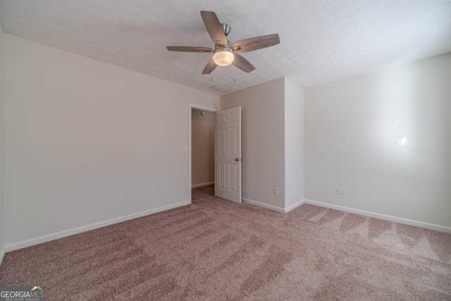 unfurnished room with ceiling fan, a textured ceiling, and light carpet