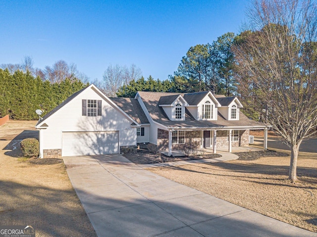 cape cod-style house featuring covered porch and a garage