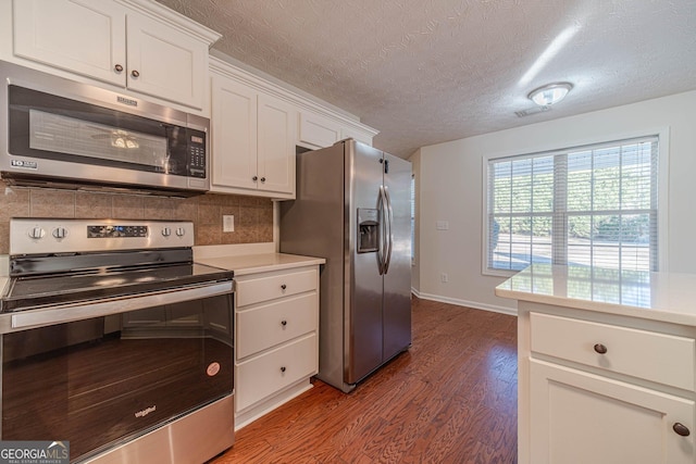 kitchen featuring white cabinetry, stainless steel appliances, decorative backsplash, dark hardwood / wood-style floors, and a textured ceiling