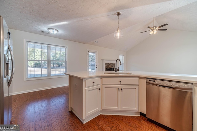 kitchen with dark wood-type flooring, white cabinetry, stainless steel appliances, sink, and kitchen peninsula