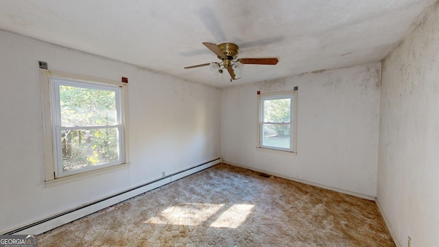 carpeted empty room with ceiling fan and a baseboard radiator