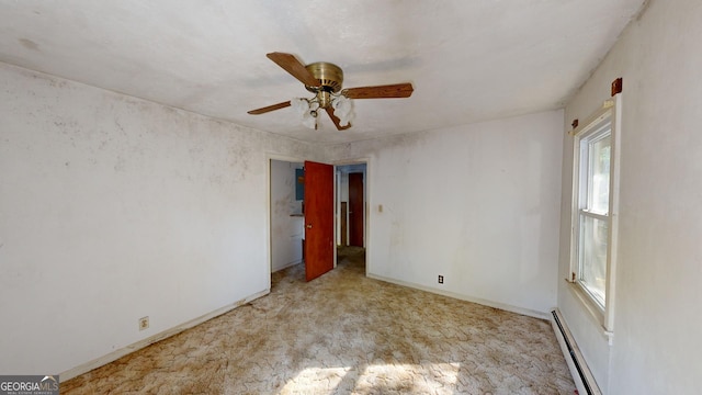 spare room featuring ceiling fan and a baseboard heating unit