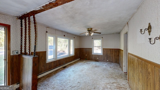 carpeted spare room with ceiling fan and baseboard heating