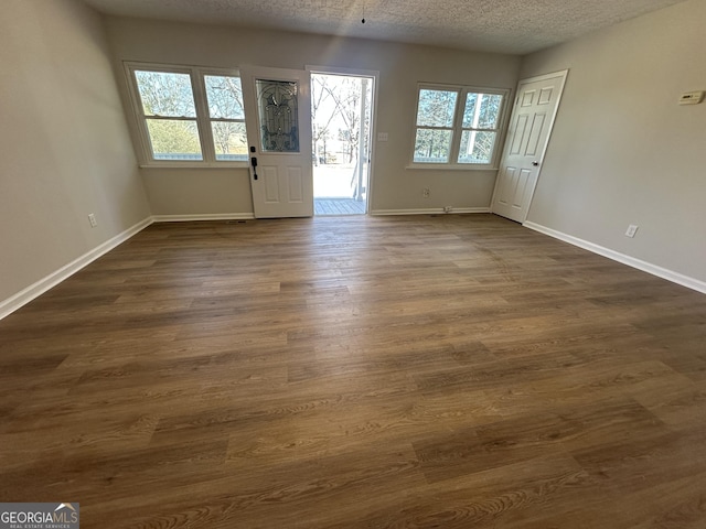 unfurnished room with a textured ceiling and dark hardwood / wood-style floors