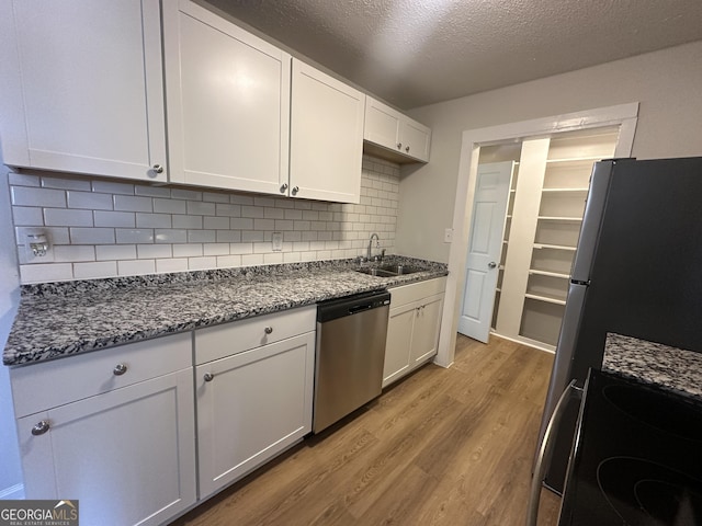 kitchen with sink, white cabinetry, appliances with stainless steel finishes, and tasteful backsplash