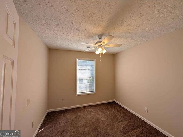 carpeted empty room featuring ceiling fan and a textured ceiling