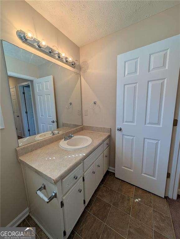 bathroom featuring a textured ceiling and vanity