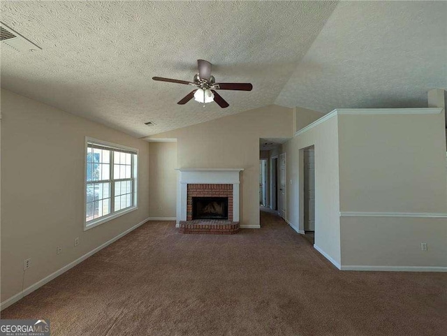 unfurnished living room with ceiling fan, vaulted ceiling, a brick fireplace, and a textured ceiling