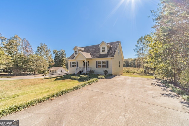 cape cod-style house featuring a front yard