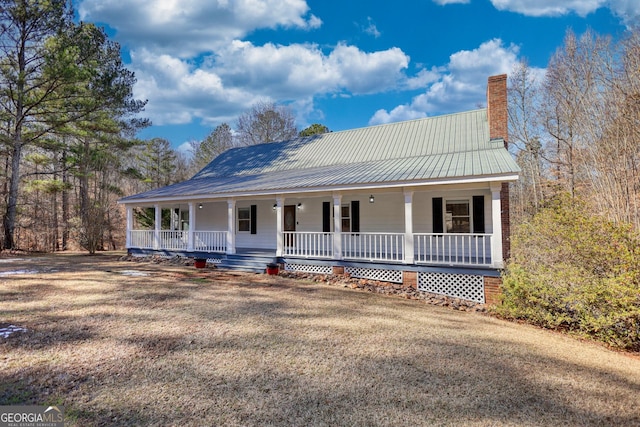 farmhouse with covered porch and a front yard