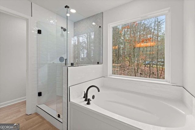 bathroom with plus walk in shower and hardwood / wood-style floors