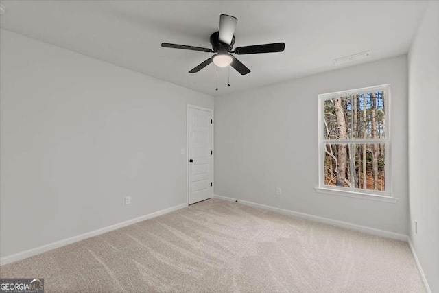 spare room with ceiling fan and light colored carpet