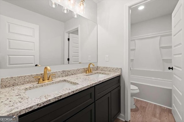 bathroom featuring toilet, hardwood / wood-style flooring, and vanity