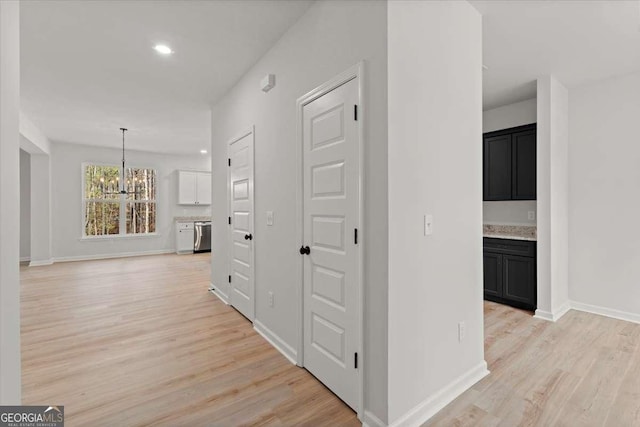 hall featuring a notable chandelier and light hardwood / wood-style floors