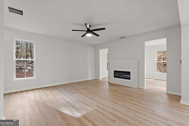 unfurnished living room featuring ceiling fan and light wood-type flooring