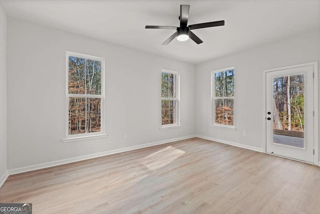 unfurnished room featuring ceiling fan, a wealth of natural light, and light hardwood / wood-style flooring