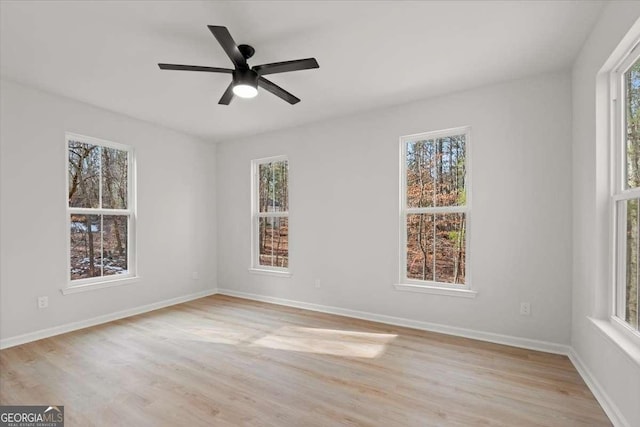 spare room featuring ceiling fan, plenty of natural light, and light hardwood / wood-style flooring