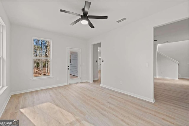 empty room with ceiling fan and light hardwood / wood-style flooring