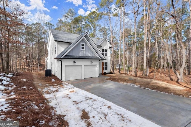 snow covered property with a garage and cooling unit