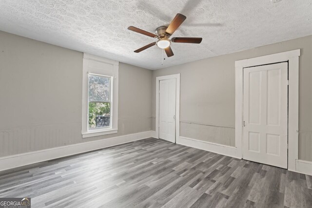 empty room with dark wood-type flooring and ceiling fan